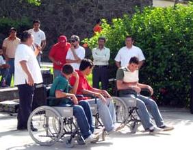 foto de tres personas en sillas de ruedas simulando discapacidad motriz durante charla de sensibilización